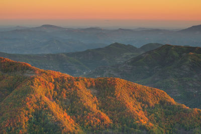 Scenic view of mountains against orange sky