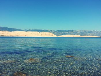 Calm sea against mountain range