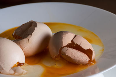 Cracked eggs on white plate with morning light. brocken eggshell