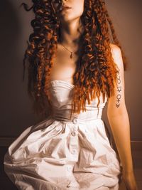 Midsection of woman standing against wall