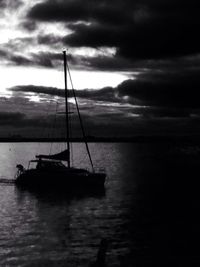 Boats in sea against cloudy sky