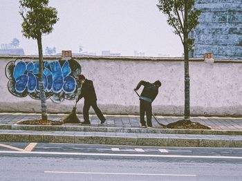 Full length rear view of man with bicycle on street