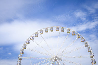 Low angle view of ferris wheel against blue sky