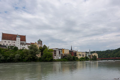 River by buildings against sky in city