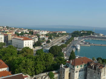 High angle view of townscape by sea against clear sky