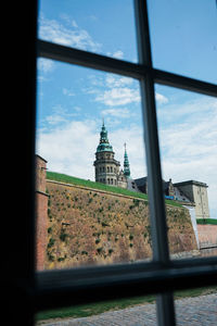 Building against sky seen through glass window