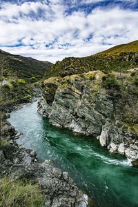 Scenic view of waterfall against sky