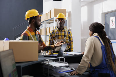 Rear view of people working at office