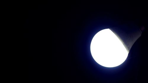 Low angle view of illuminated moon against sky at night