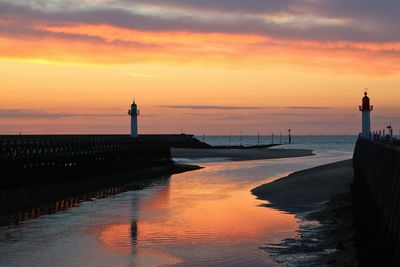 Silhouette of seascape and lighthouse during sunset