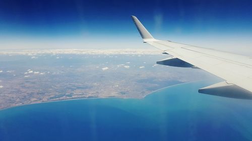 Cropped image of airplane wing over landscape