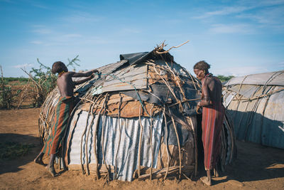 Rear view of people on land against sky