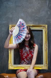 Portrait of a smiling young woman holding umbrella