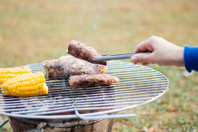 Cropped image of meat on barbecue grill