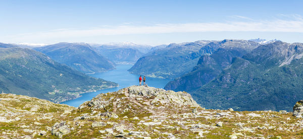 Man walking on snowcapped mountain against sky