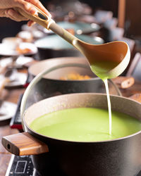 Close-up of hand pouring tea cup