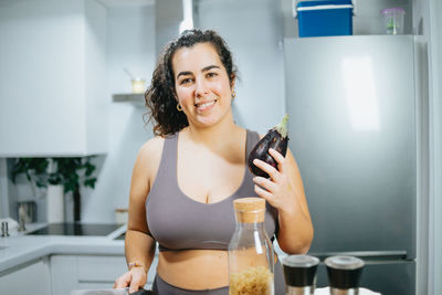 Portrait of young woman using mobile phone at home