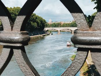 Bridge over river against sky in city