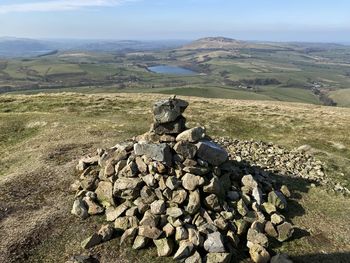Stack of rocks on field against sky