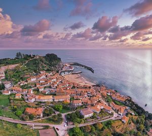 High angle view of townscape by sea against sky