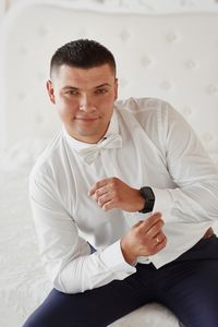 Portrait of man sitting on sofa at home