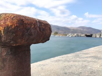 Close-up of rock by sea against sky