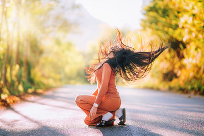 Side view of woman sitting outdoors