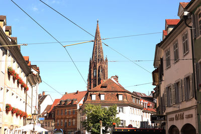 Freiburg münster seen from a distance, with old buildings lining the street