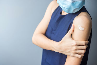 Midsection of woman standing against blue background