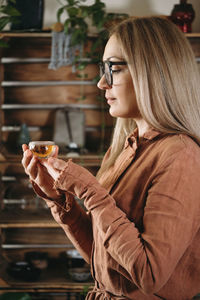 Women preparing tea ceremony in boho style atmospheric room with plants in studio. transparent tea