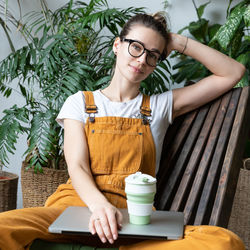 Young businesswoman freelance florist, indoor plants shop owner sit in home garden relax after work