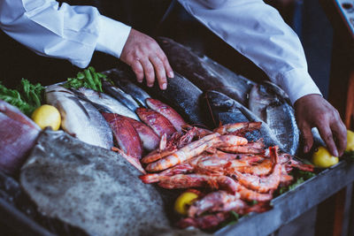 Cropped hands of man selling seafood at market