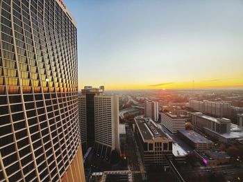 Modern buildings against sky during sunset in city