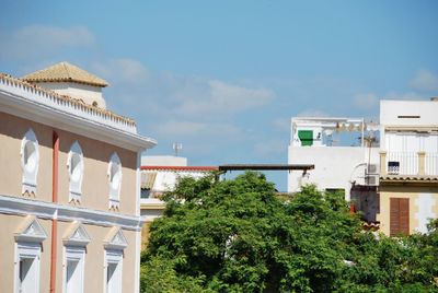 Low angle view of trees and building against sky