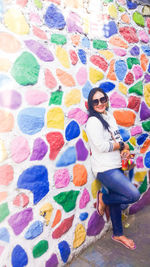 Portrait of woman standing against graffiti wall
