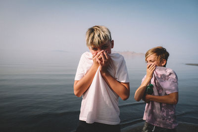 Boys cover their noses to avoid the sulphur smell at great salt lake.