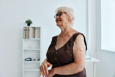 Mid adult woman standing against wall at home