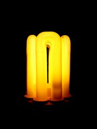 Close-up of illuminated light bulb against black background