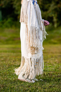 Low section of woman standing on field