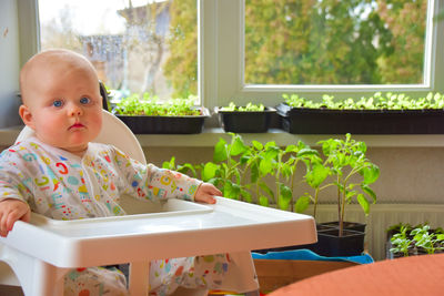 Cute boy looking through window at home