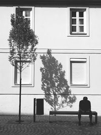 Rear view of man sitting outside building