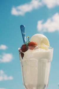 Close-up of ice cream in glass against sky