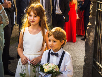 Boy and girl standing at entrance during wedding ceremony