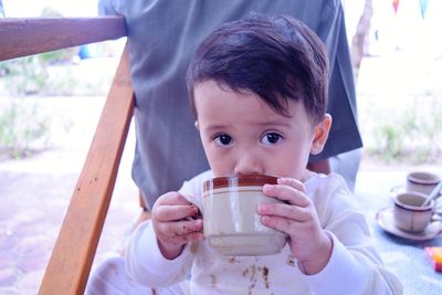 Portrait of boy drinking coffee