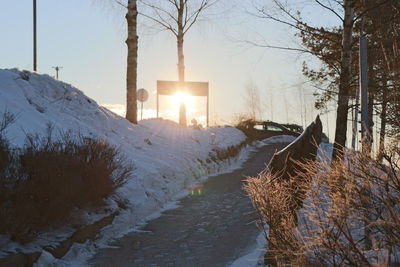 Scenic view of snowcapped field against sky during sunset