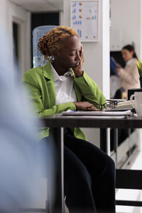 Side view of young man using mobile phone in office