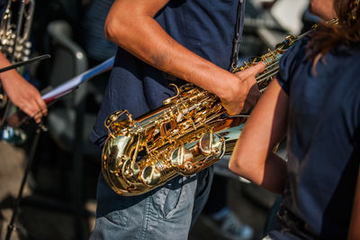 Midsection of man playing saxophone in city