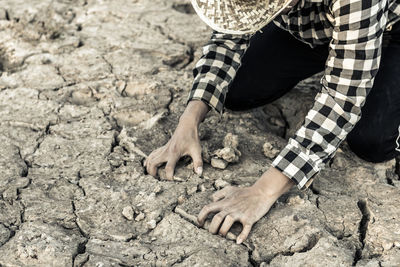 Woman kneeling on barren field