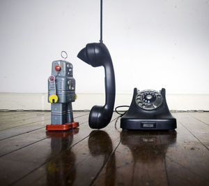 Close-up of telephone booth on table against wall