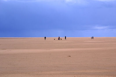 People on desert against sky